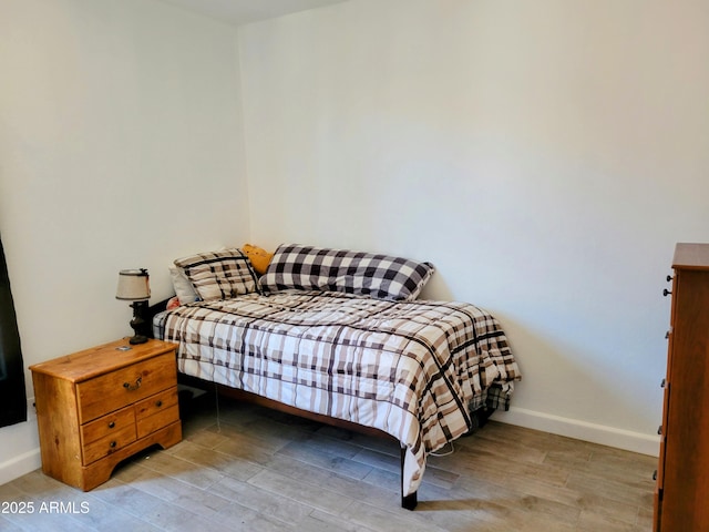 bedroom featuring baseboards and wood finished floors