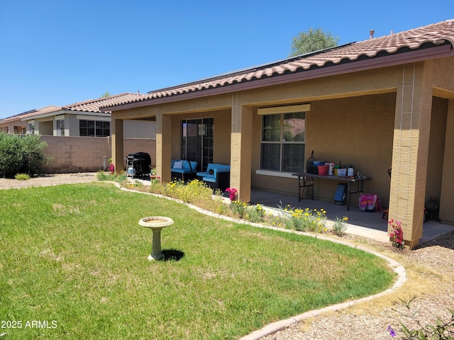 back of house featuring fence, stucco siding, a patio area, a lawn, and a tile roof
