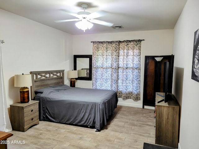 bedroom featuring a ceiling fan, baseboards, visible vents, and light wood-style flooring