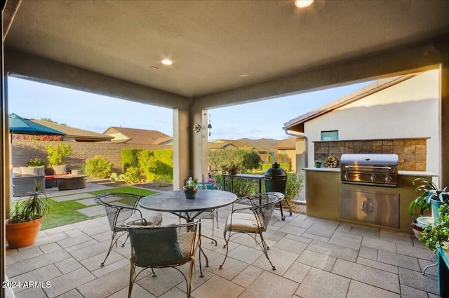 view of patio / terrace featuring a grill, a mountain view, an outdoor kitchen, and a fire pit