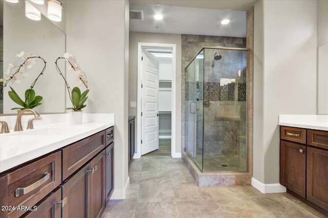 bathroom with vanity and a shower with door