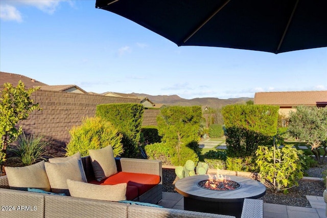 view of patio with a mountain view and an outdoor fire pit