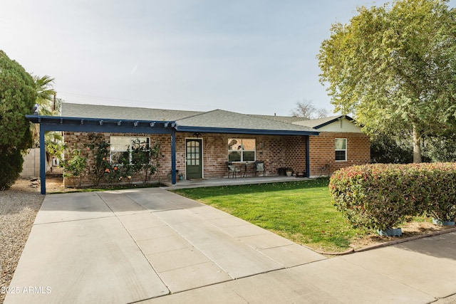 ranch-style house with a front lawn and a patio