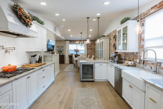 kitchen with wine cooler, hanging light fixtures, white cabinetry, and custom exhaust hood