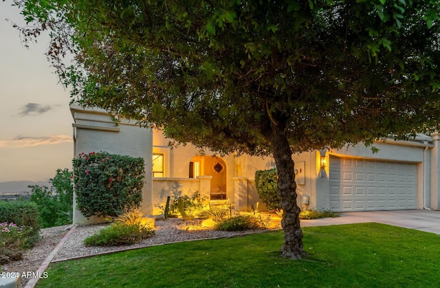 view of front facade featuring a garage and a yard