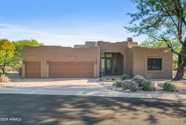 pueblo-style house with a garage