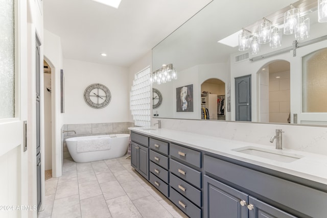 bathroom featuring vanity, tile patterned floors, and a washtub