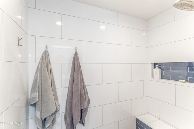 bathroom featuring walk in shower and tile walls