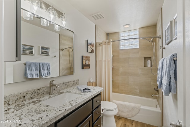 full bathroom with toilet, vanity, hardwood / wood-style floors, and shower / bath combo with shower curtain