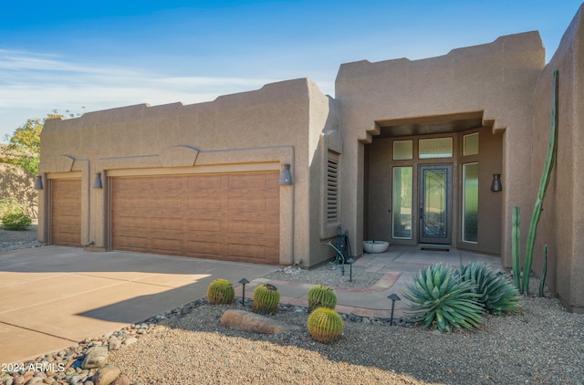 pueblo revival-style home featuring a garage