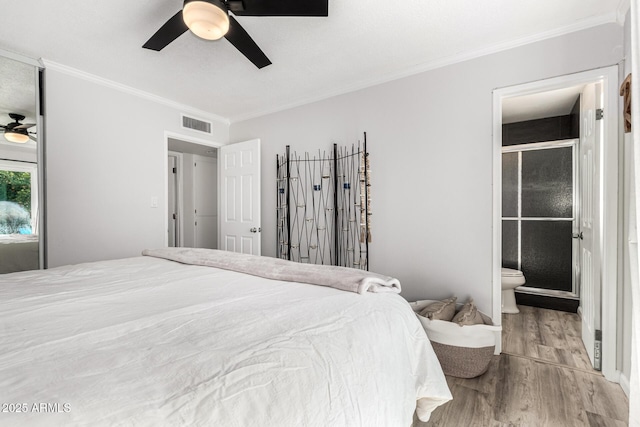 bedroom with visible vents, a ceiling fan, wood finished floors, connected bathroom, and crown molding