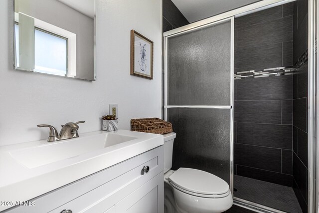 bathroom with a stall shower, toilet, and vanity