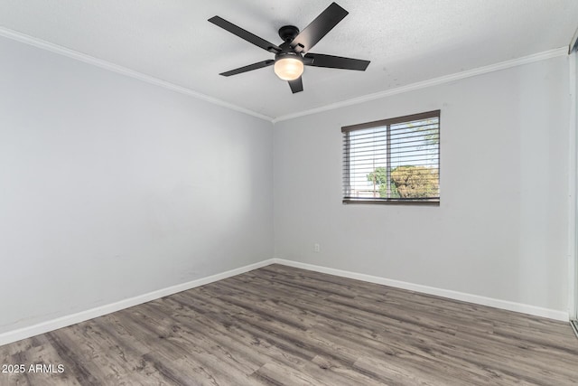 empty room with ceiling fan, wood finished floors, baseboards, and ornamental molding