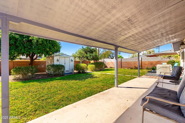 view of patio / terrace with a storage unit, a fenced backyard, and an outdoor structure