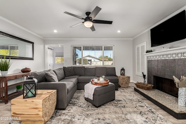 living area with recessed lighting, wood finished floors, ornamental molding, and a ceiling fan