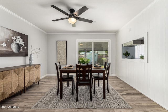 dining area with ornamental molding, a ceiling fan, baseboards, and wood finished floors