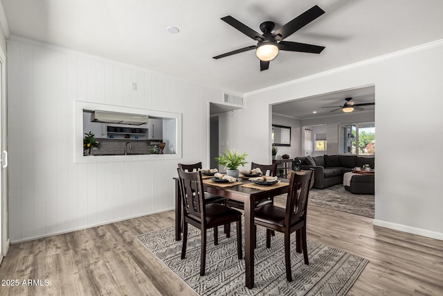 dining area with visible vents, crown molding, baseboards, and wood finished floors