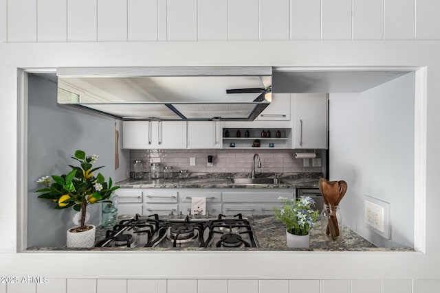 kitchen with a ceiling fan, a sink, open shelves, backsplash, and white cabinetry