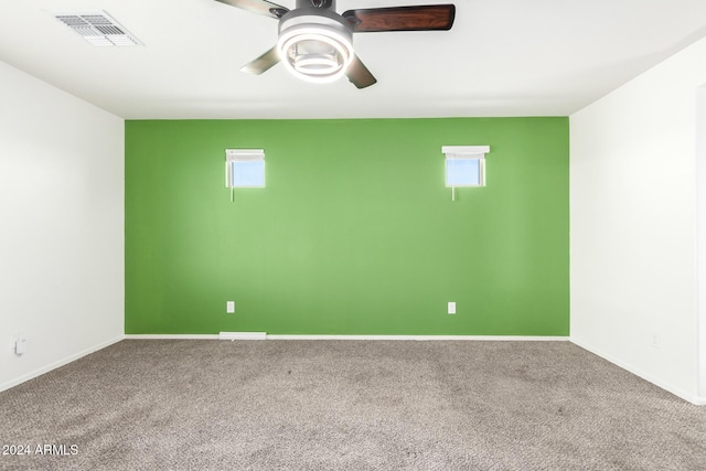 spare room with carpet flooring, ceiling fan, and a wealth of natural light