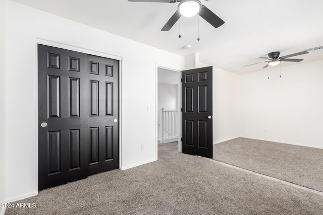 unfurnished bedroom featuring ceiling fan, a closet, and carpet