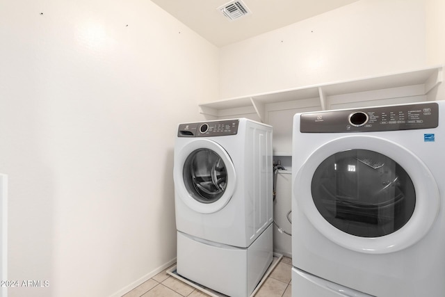 laundry area featuring separate washer and dryer and light tile patterned flooring