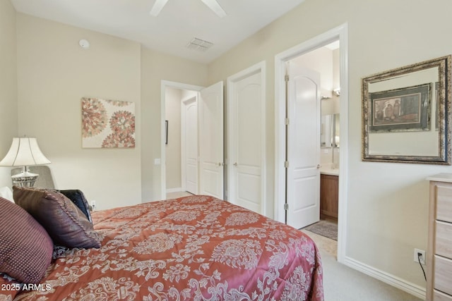 bedroom featuring ensuite bathroom, light carpet, ceiling fan, and a closet