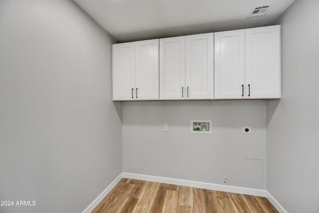 laundry room featuring electric dryer hookup, cabinets, light wood-type flooring, and hookup for a washing machine