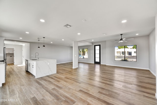 unfurnished living room featuring ceiling fan, sink, and light hardwood / wood-style flooring