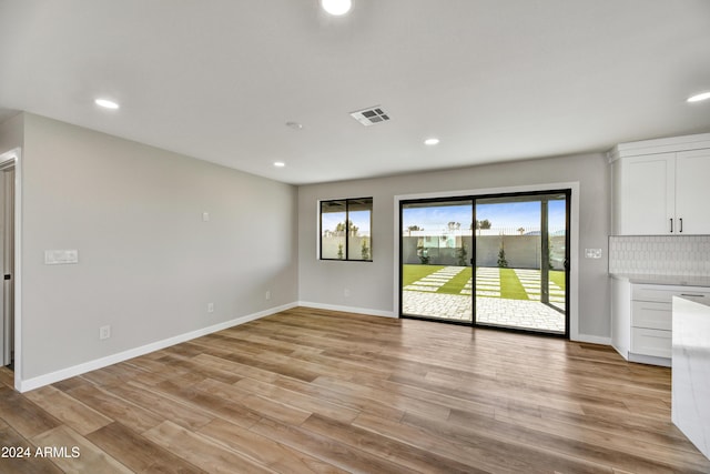 unfurnished living room featuring light hardwood / wood-style flooring and a wealth of natural light