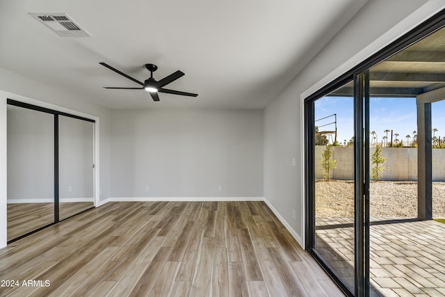 unfurnished bedroom featuring access to exterior, ceiling fan, a closet, and light hardwood / wood-style flooring