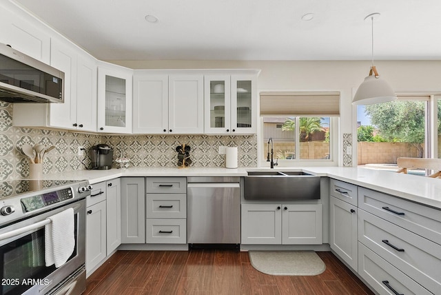 5912 E Wethersfield Rd, Scottsdale, AZ 85254 - kitchen with appliances with stainless steel finishes, light countertops, tasteful backsplash, dark wood finished floors, and decorative light fixtures