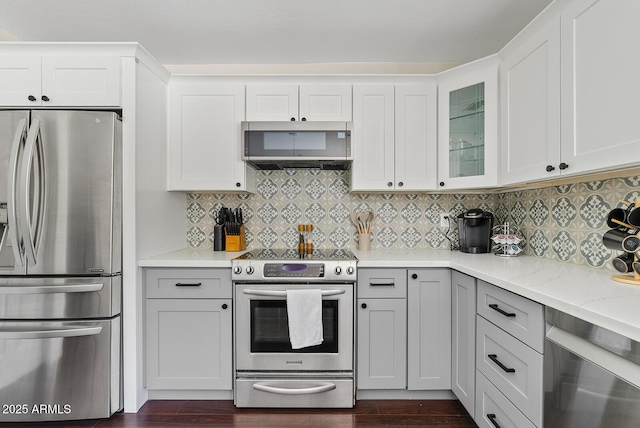 5912 E Wethersfield Rd, Scottsdale, AZ 85254 - kitchen featuring stainless steel appliances, dark wood-style floors, glass insert cabinets, and backsplash