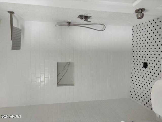 bathroom featuring tiled shower and tile patterned flooring