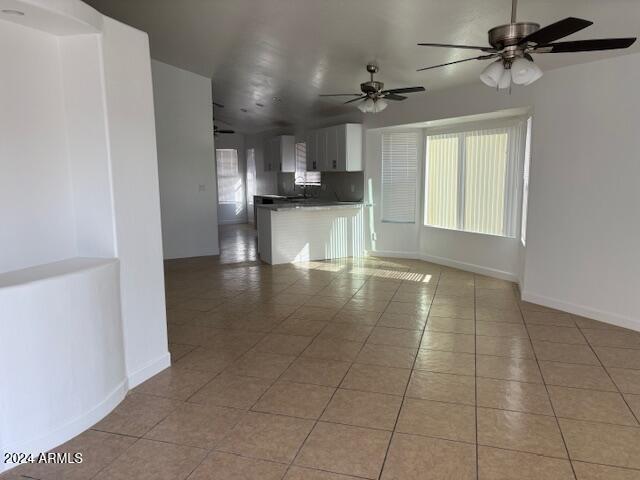 unfurnished living room featuring ceiling fan and light tile patterned flooring