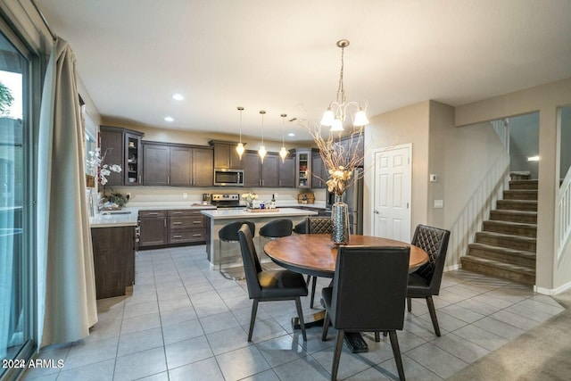 dining room with sink, a notable chandelier, and light tile patterned flooring