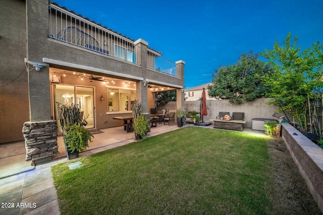 back of house with a lawn, a patio area, and a balcony