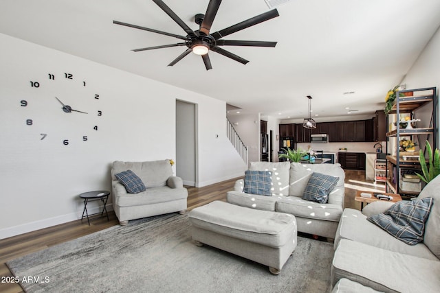 living room featuring wood-type flooring and ceiling fan