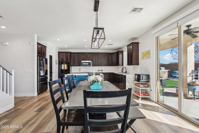 dining area with light hardwood / wood-style flooring, sink, a wealth of natural light, and ceiling fan