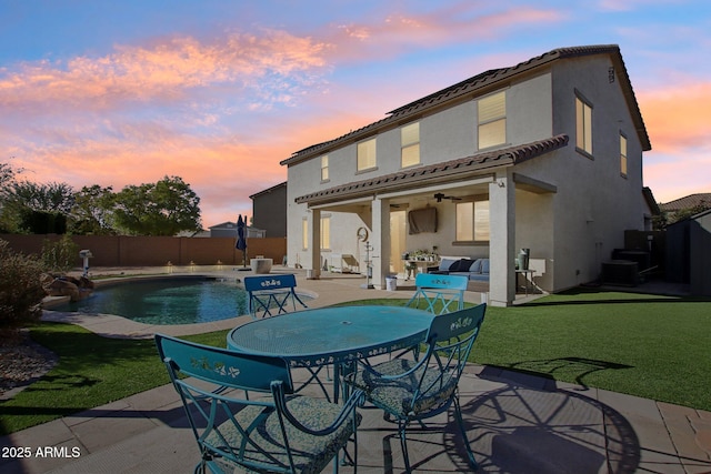 back of house with a fenced in pool, a lawn, ceiling fan, and a patio area