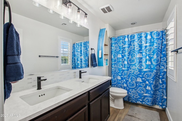 bathroom featuring tasteful backsplash, vanity, hardwood / wood-style floors, and toilet