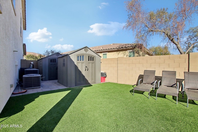 view of yard featuring central air condition unit and a storage unit