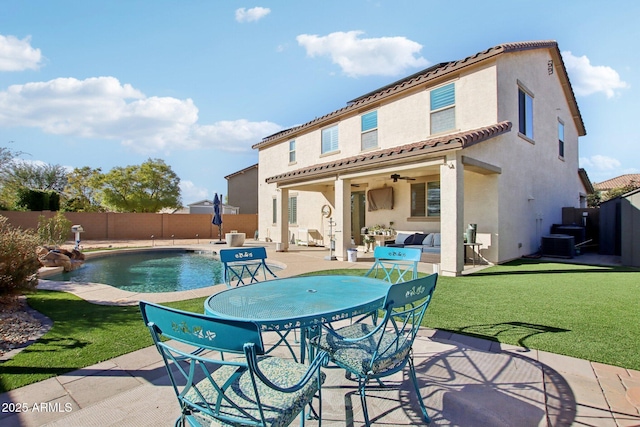 back of property featuring a fenced in pool, a lawn, ceiling fan, and a patio area