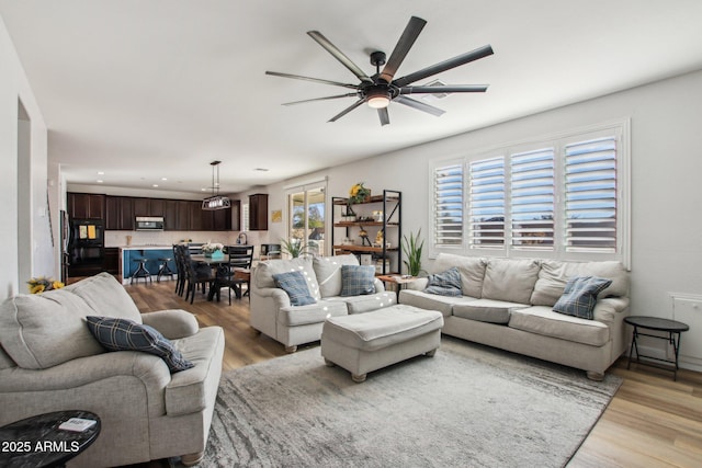 living room with ceiling fan and light hardwood / wood-style floors