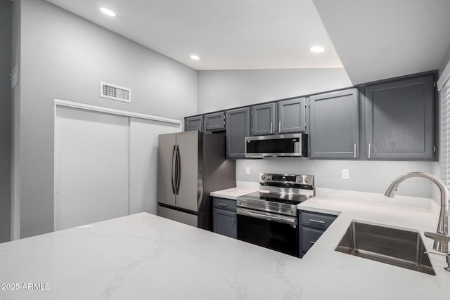 1055 E Ingram St, Mesa, AZ 85203 - kitchen featuring appliances with stainless steel finishes, light stone countertops, lofted ceiling, recessed lighting, and gray cabinetry