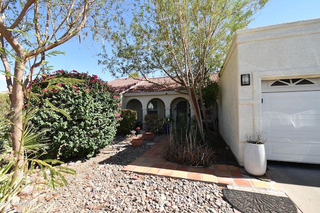 property entrance featuring a tiled roof and stucco siding