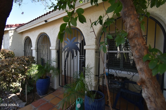 doorway to property with a tiled roof and stucco siding