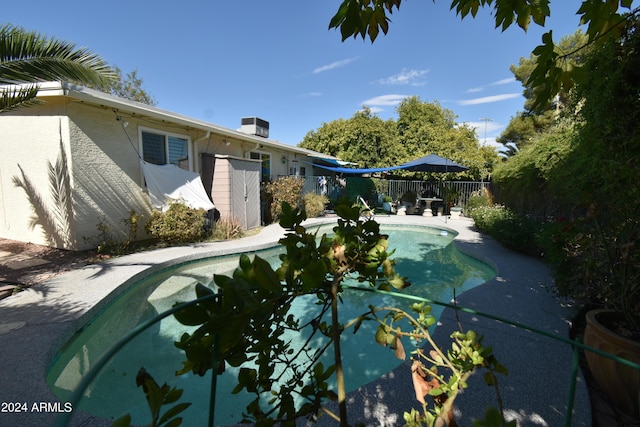 view of swimming pool featuring central AC, fence, and a fenced in pool