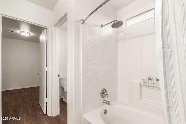 bathroom featuring hardwood / wood-style flooring, toilet, and shower / bath combination