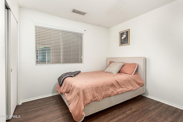 bedroom featuring dark hardwood / wood-style flooring and a closet