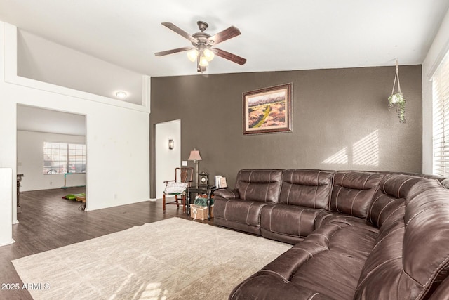 living room with ceiling fan, dark hardwood / wood-style flooring, and vaulted ceiling